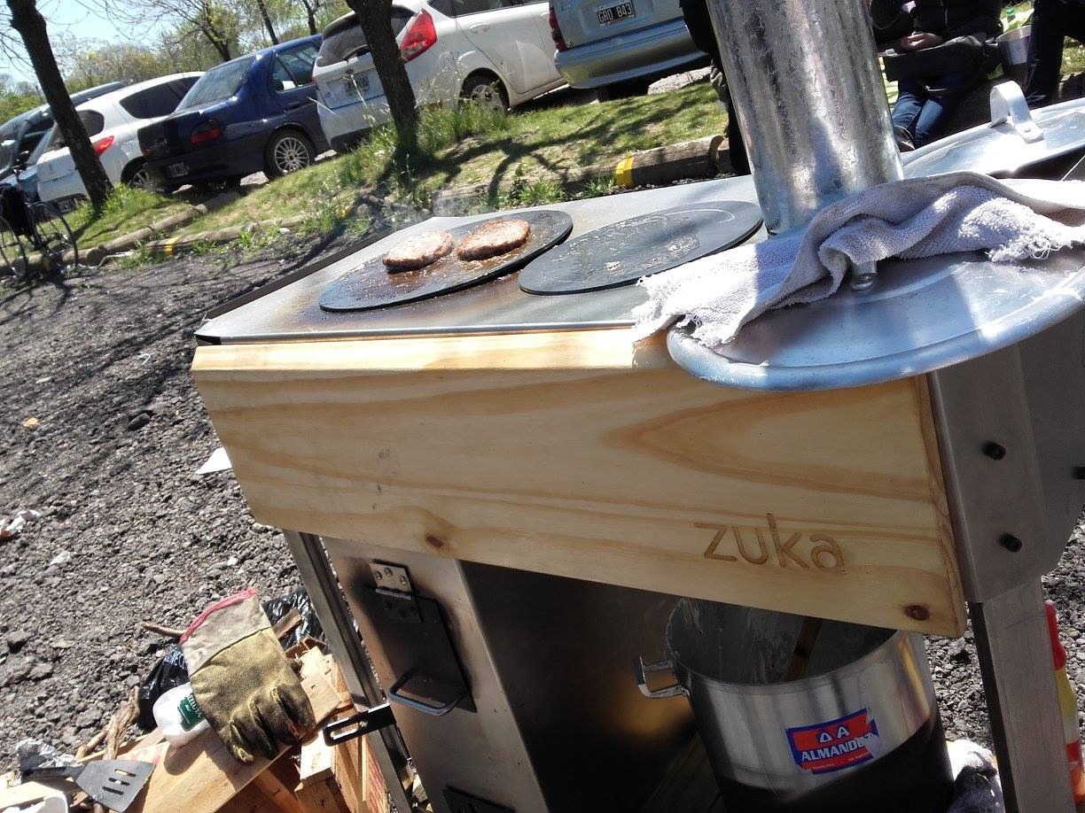 Zuka wood-fired cookstove — two pots on the cooktop, chimney and branded pine facia